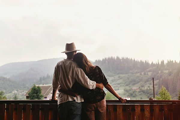 A couple overlooking rolling hills.